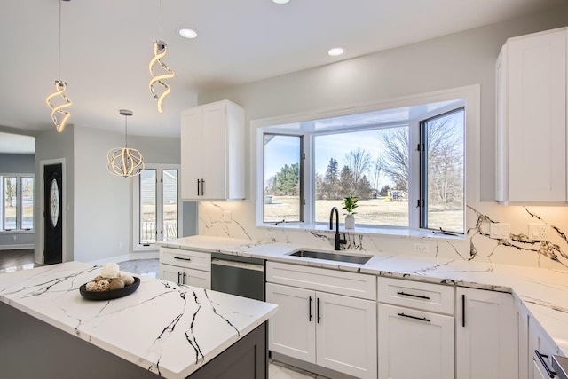 kitchen with a kitchen island, dishwasher, hanging light fixtures, and white cabinets