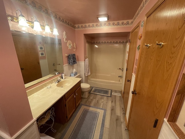 full bathroom featuring wood-type flooring, toilet, shower / bath combination, and vanity