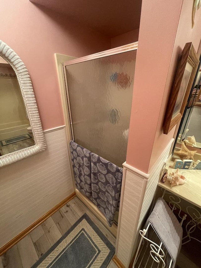 bathroom with an enclosed shower and hardwood / wood-style floors