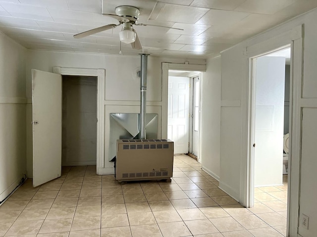 interior space with ceiling fan, heating unit, and light tile patterned floors