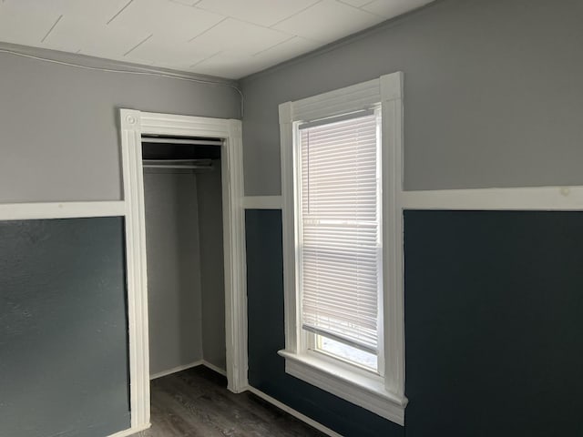 unfurnished bedroom featuring dark hardwood / wood-style flooring and a closet