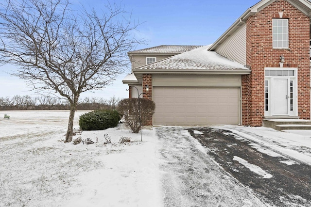 view of snowy exterior featuring a garage