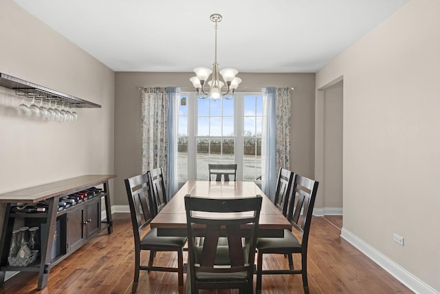 dining room with dark hardwood / wood-style flooring and a chandelier