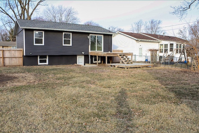 back of property with a wooden deck and a lawn