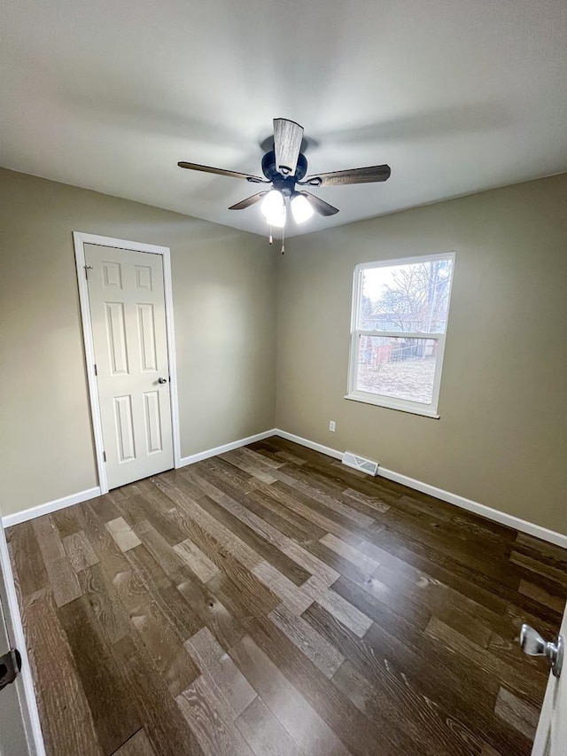 unfurnished room featuring dark hardwood / wood-style flooring and ceiling fan