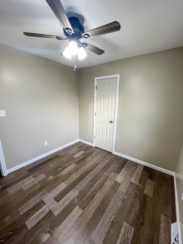 empty room with ceiling fan and dark hardwood / wood-style flooring