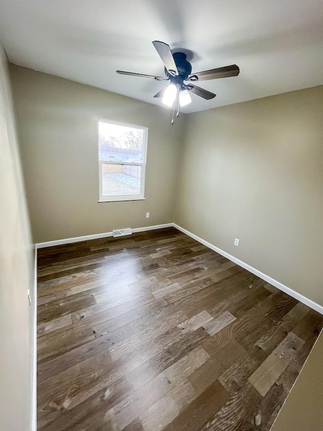 empty room with dark hardwood / wood-style floors and ceiling fan