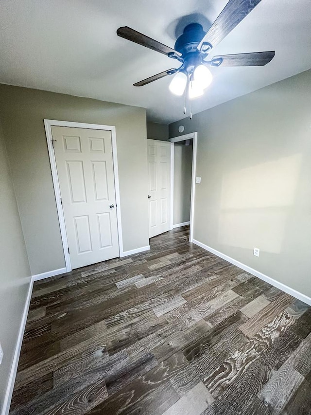 unfurnished bedroom featuring dark hardwood / wood-style floors, ceiling fan, and a closet