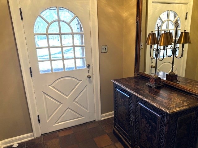entryway with baseboards, stone finish flooring, and a wealth of natural light