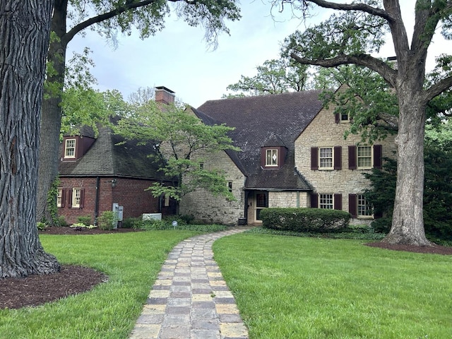 2221 Twin Oak Rd, Peru, IL 61354 - view of front of home with stone siding, a front lawn, a chimney, and brick siding