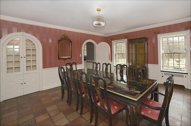 2221 Twin Oak Rd, Peru, IL 61354 - dining room featuring a wainscoted wall, healthy amount of natural light, ornamental molding, wallpapered walls, and arched walkways