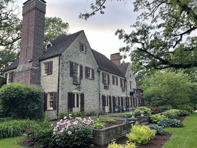 exterior space with a chimney and stone siding