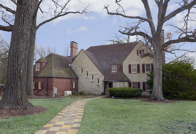 2221 Twin Oak Rd, Peru, IL 61354 - view of front facade featuring stone siding, a chimney, a front yard, central AC unit, and brick siding