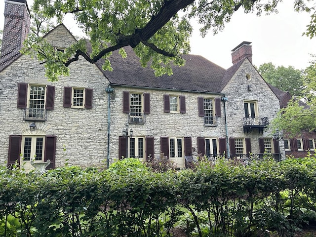 view of front of property featuring a chimney and stone siding