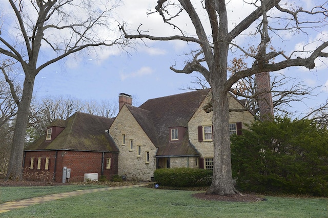 2221 Twin Oak Rd, Peru, IL 61354 - view of home's exterior featuring a chimney, stone siding, a yard, and brick siding