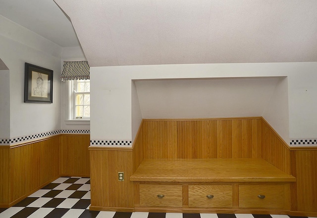 mudroom with wainscoting, wooden walls, and dark floors
