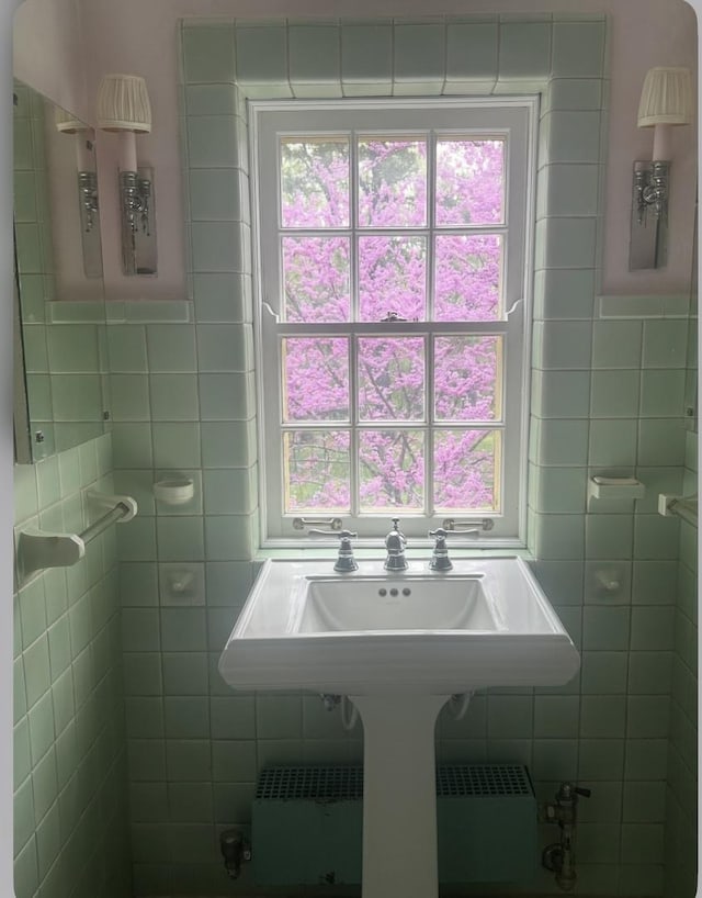 bathroom with tile walls, plenty of natural light, and radiator heating unit