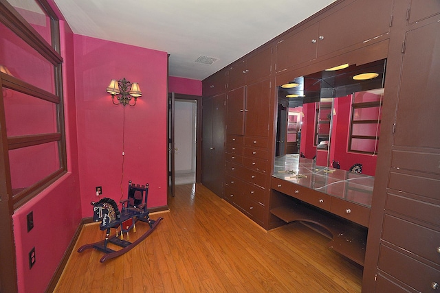 interior space featuring light wood-style floors, baseboards, and visible vents
