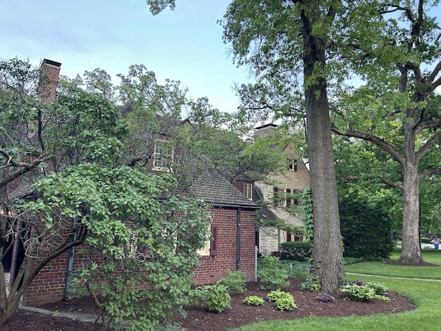 view of side of property featuring brick siding and a chimney