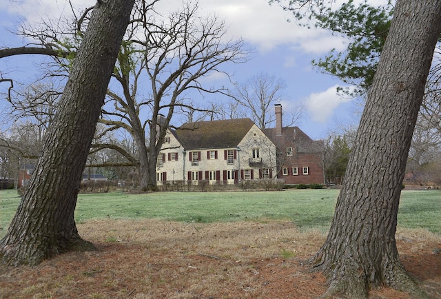 2221 Twin Oak Rd, Peru, IL 61354 - colonial-style house with a chimney, stone siding, and a front lawn
