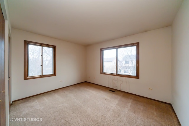 empty room with plenty of natural light and light carpet