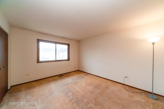 spare room featuring light carpet