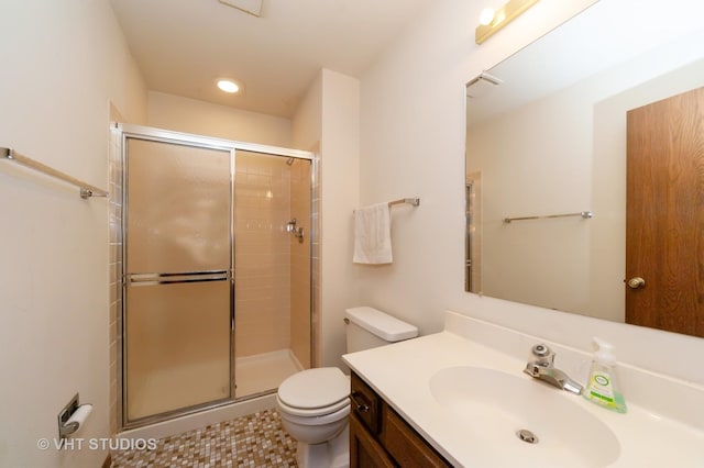 bathroom with vanity, a shower with shower door, and toilet