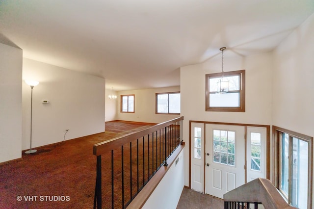 entrance foyer featuring a notable chandelier and carpet flooring