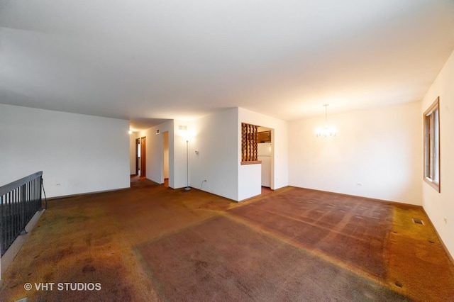 unfurnished living room featuring an inviting chandelier and dark colored carpet