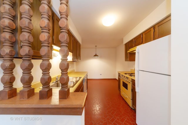 kitchen with sink, kitchen peninsula, white appliances, and decorative light fixtures