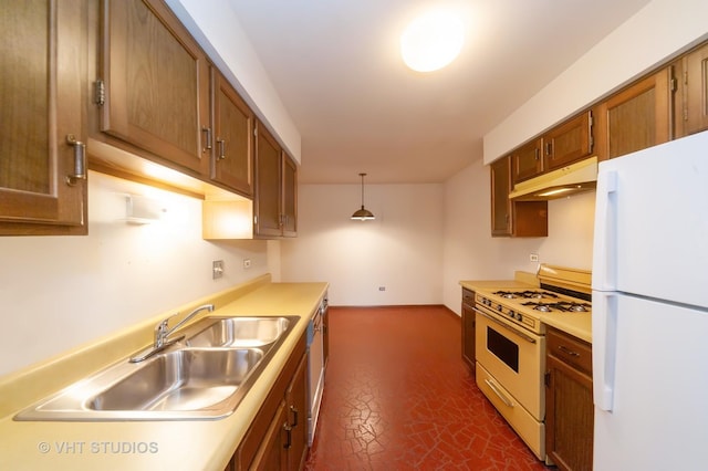 kitchen with sink, white appliances, and decorative light fixtures