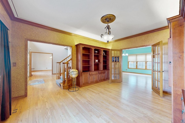 hallway featuring light hardwood / wood-style flooring, ornamental molding, and french doors