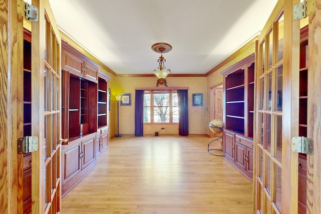 interior space featuring ornamental molding, french doors, and light wood-type flooring