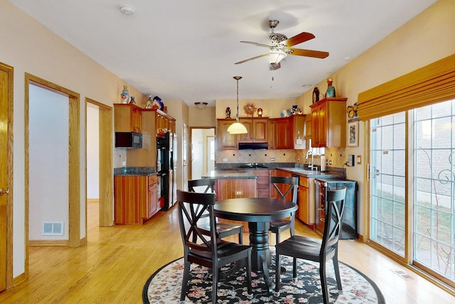 dining space with sink, light hardwood / wood-style flooring, and ceiling fan