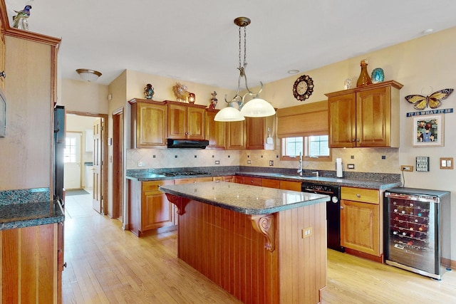 kitchen with sink, hanging light fixtures, a kitchen island, beverage cooler, and black appliances