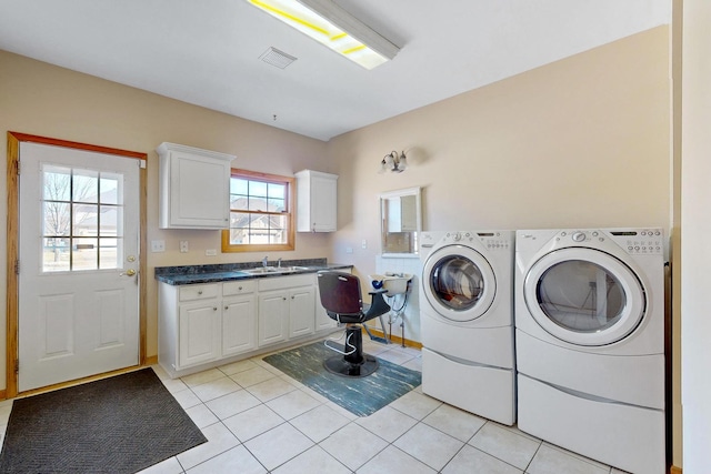 laundry area featuring cabinets, washing machine and dryer, sink, and light tile patterned floors