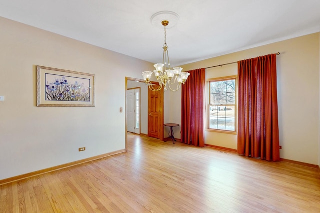 unfurnished room with an inviting chandelier and light hardwood / wood-style flooring