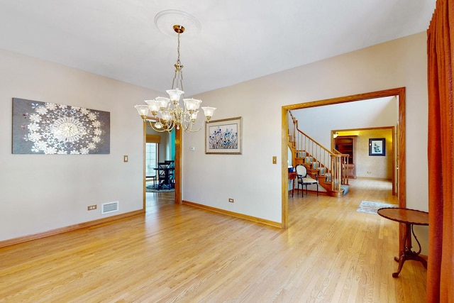 empty room with an inviting chandelier and light wood-type flooring