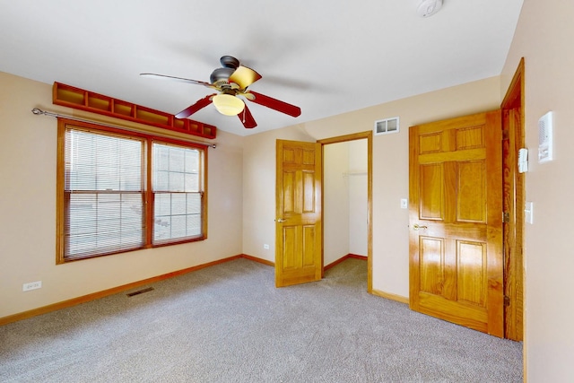 unfurnished bedroom with ceiling fan and light colored carpet