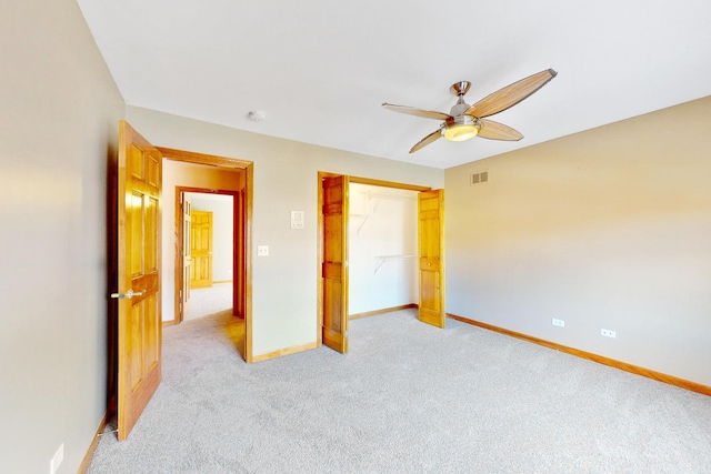 unfurnished bedroom with light carpet, a closet, and ceiling fan