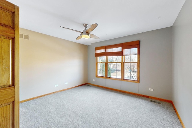 carpeted spare room featuring ceiling fan