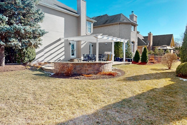 rear view of house with a yard, a pergola, and a patio