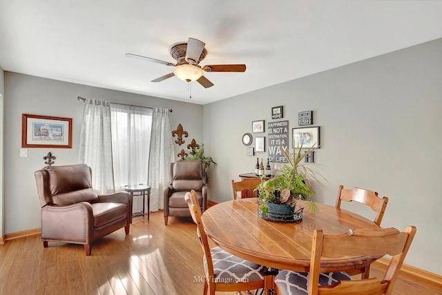 dining space with ceiling fan and light hardwood / wood-style flooring