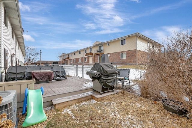 wooden deck featuring a playground, a grill, and cooling unit