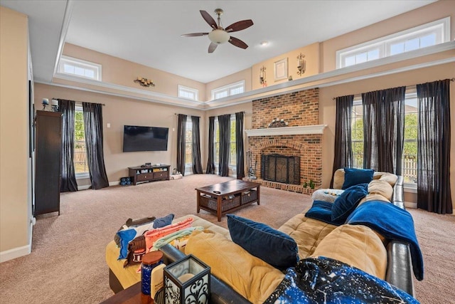 living room featuring carpet floors, a ceiling fan, baseboards, and a brick fireplace