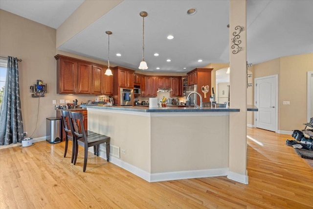 kitchen with recessed lighting, baseboards, stainless steel oven, and light wood-style floors