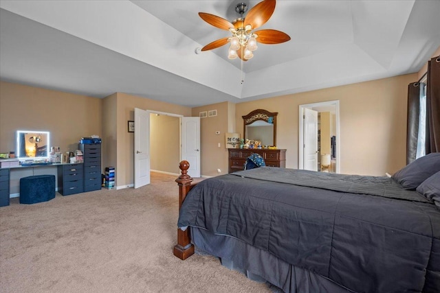 carpeted bedroom featuring baseboards, ceiling fan, visible vents, and a raised ceiling