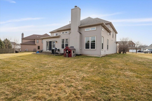 rear view of house with a lawn, a patio area, and a chimney