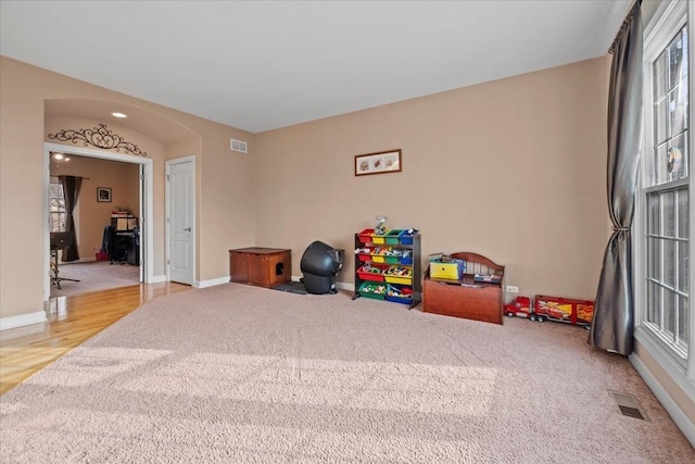 rec room featuring carpet floors, baseboards, and visible vents