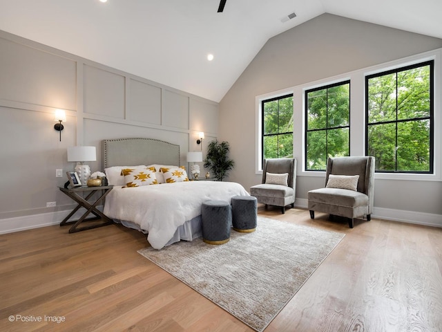 bedroom with vaulted ceiling and light hardwood / wood-style flooring